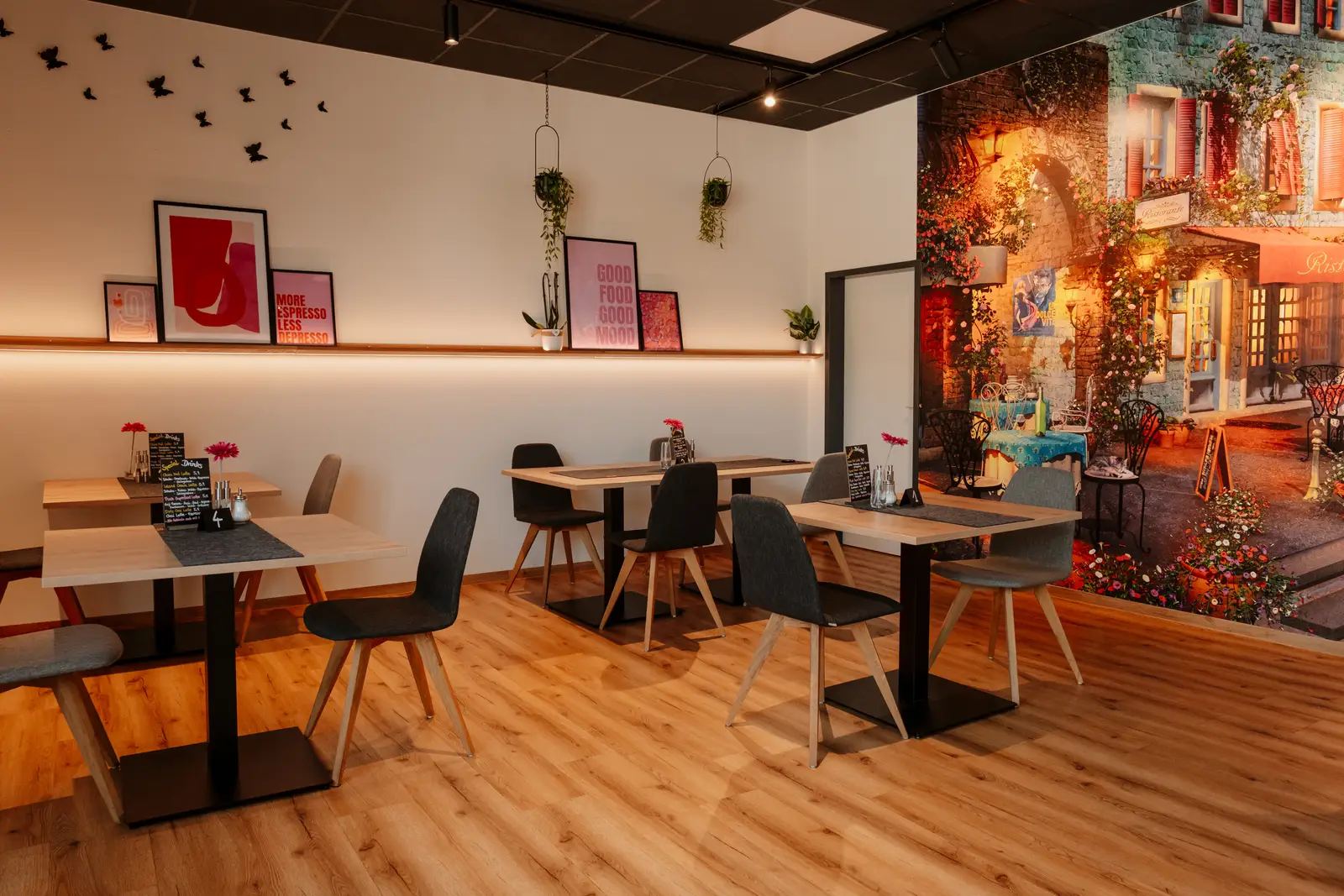 Gastraum des Café NoYa mit gemütlichen Sitzplätzen und großem Wandbild